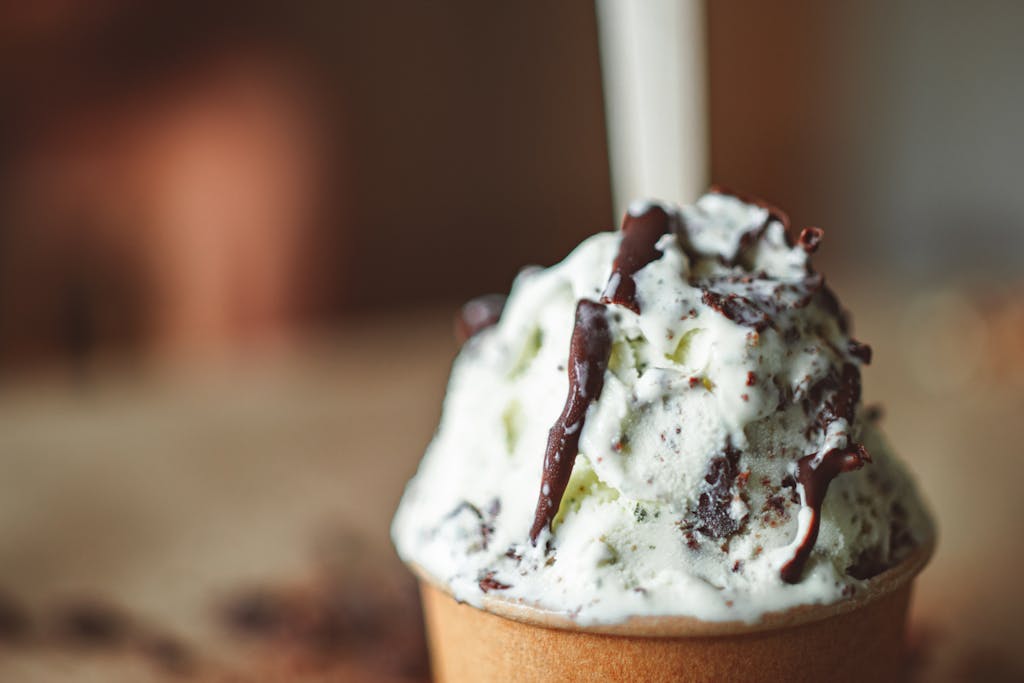 Indulge in a creamy ice cream adorned with rich chocolate drizzle for a decadent treat.